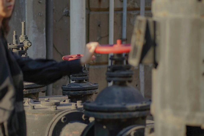 person holding red and black metal tool